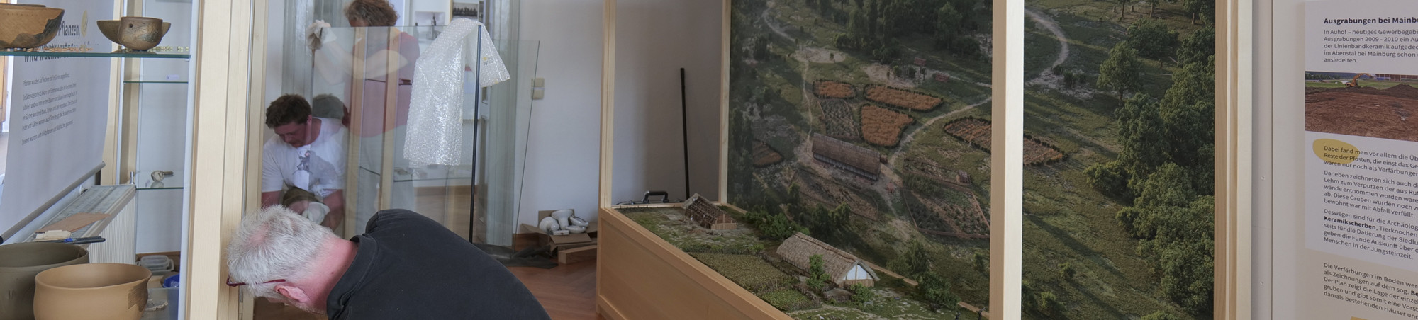 Firma Geisreither setzt die große Glasscheibe in die Vitrine ein.