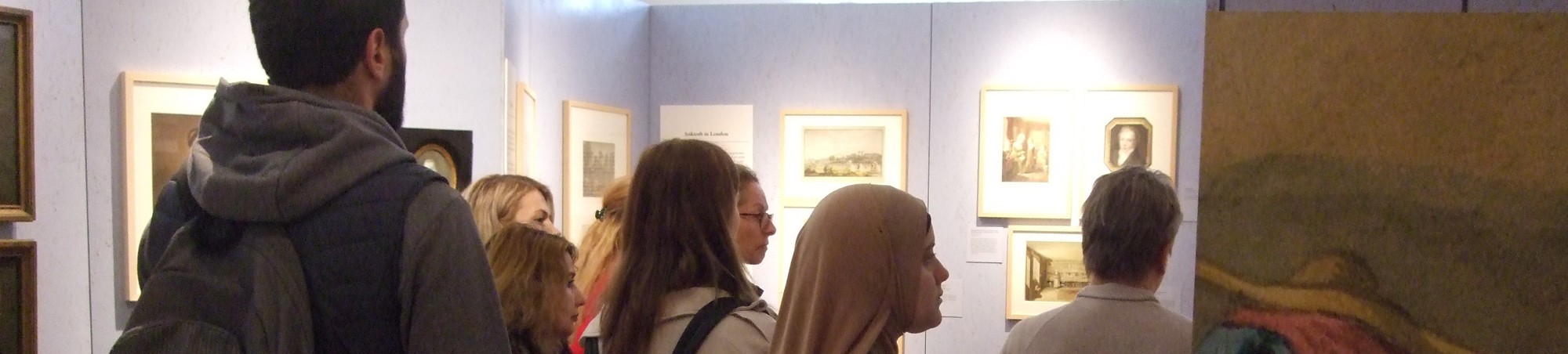 Teilnehmer und Teilnehmerinnen betrachten zeichnungen von Georg Scharf.