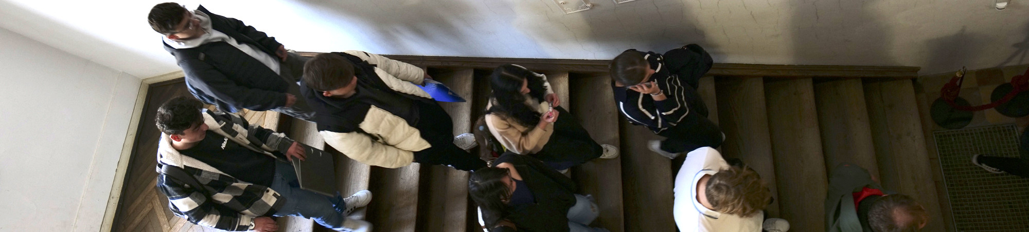 Gynasiastinnen und Gynasiasten im Treppenhaus aus Vogelperspektive