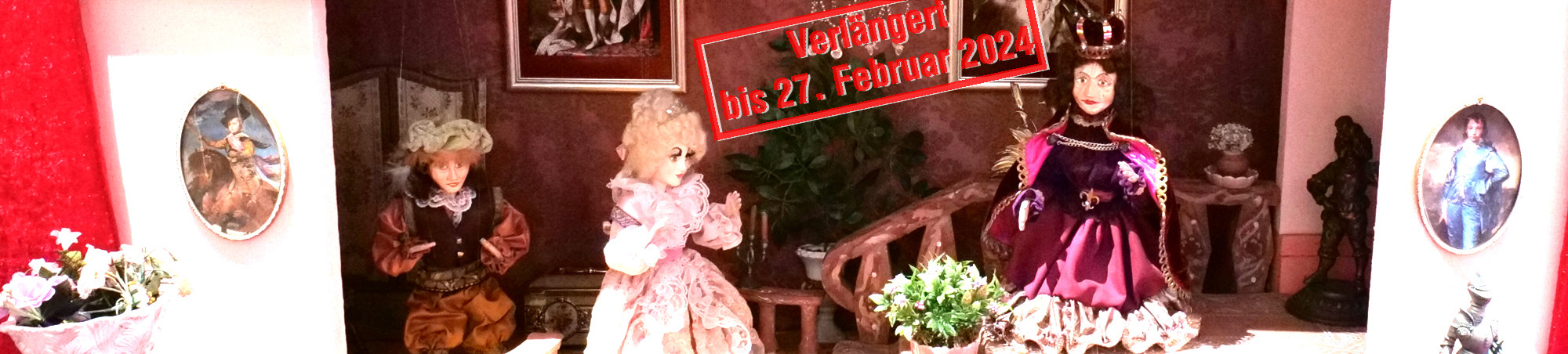 In einem barocken Schloss mit Kronleuchter und Ahnenbildern sitzt der König auf einem Podest und mit einigen Abstand neben ihm stehen Prinzessin und Diener.